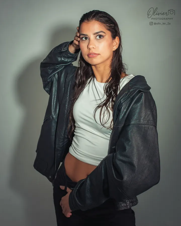 Contemporary model portfolio portrait with wet-look hair and an oversized leather jacket
